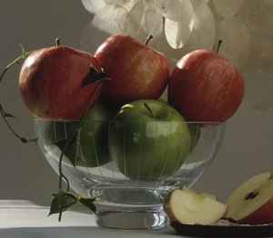 Decorating a fireplace mantel for Christmas with glass bowl and apples