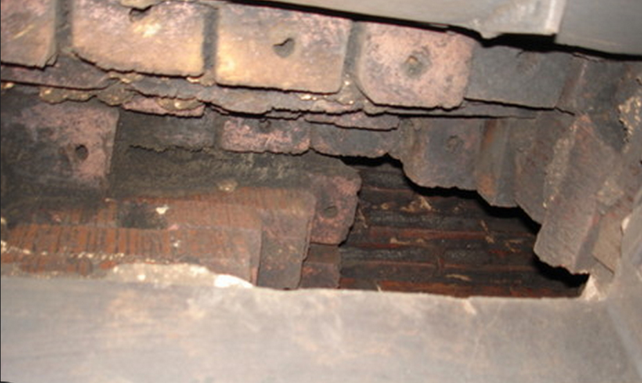 Damage from a chimney fire to chimney's smoke chamber.
