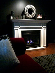 The white fireplace, dark walls and spot lighting create striking contrasts for this first fire of the season.