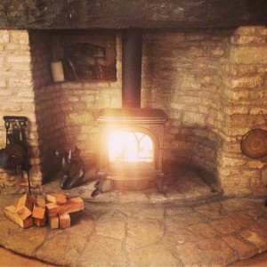 A Gracious Stone Hearth is the Setting for This First Wood Stove Fire of the Season.