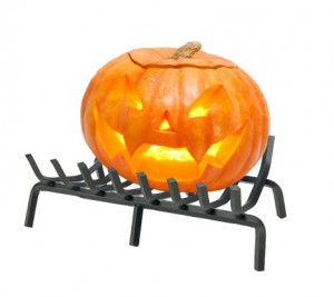 Jack o'lantern with lit candle on fireplace grate.