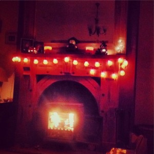 Pumpkin garland lights accent the Halloween mantel.