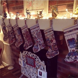 Seven handmade-with-love cross stitched stockings adorn this Christmas mantel.
