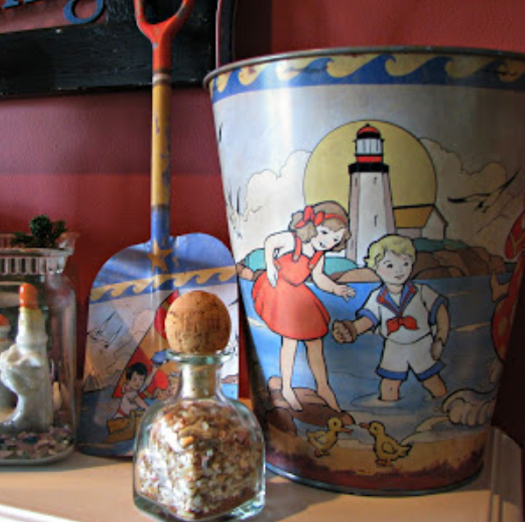 A reproduction vintage child's sand bucket and shovel adorn this mantel.