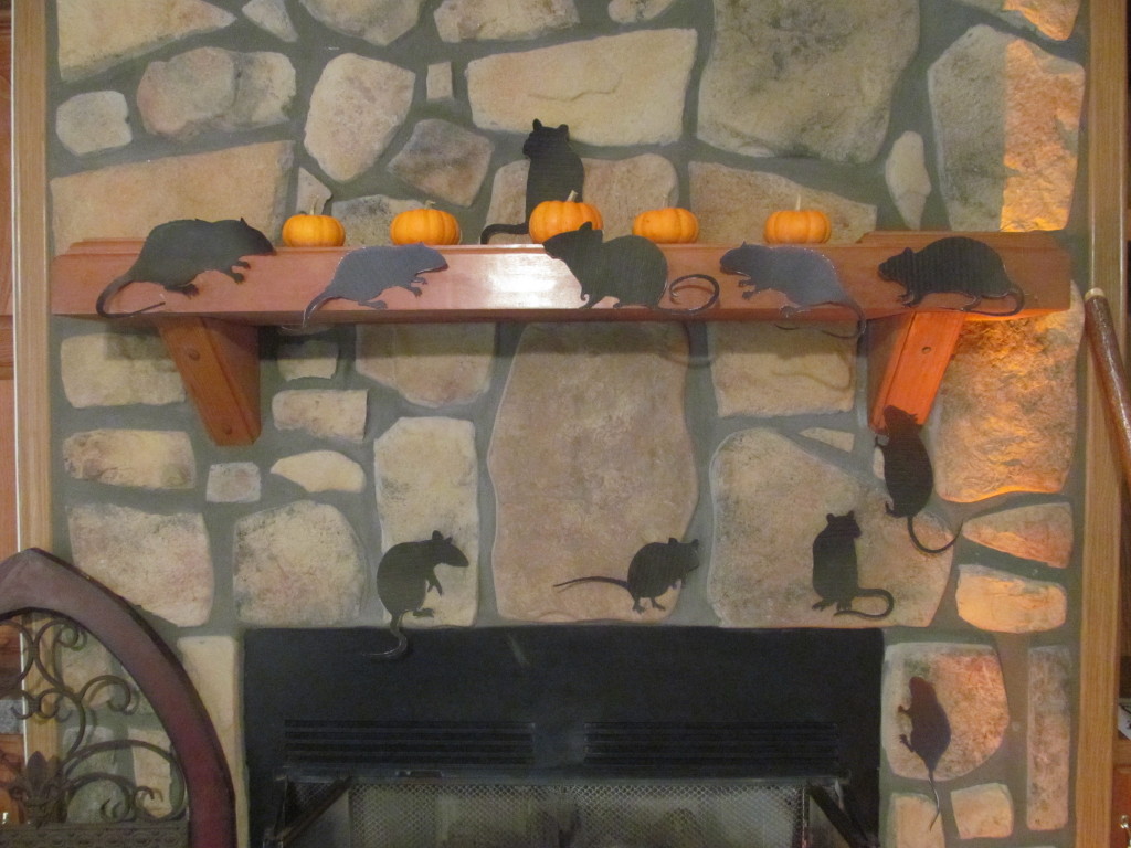 Halloween rats scamper around the fireplace.