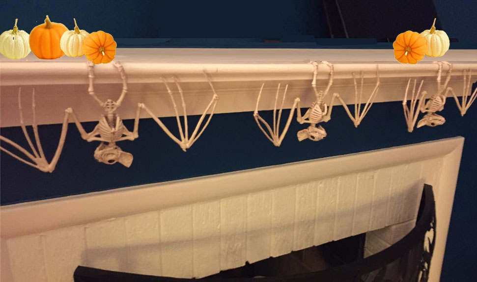 skeleton bats hang on fireplace mantel